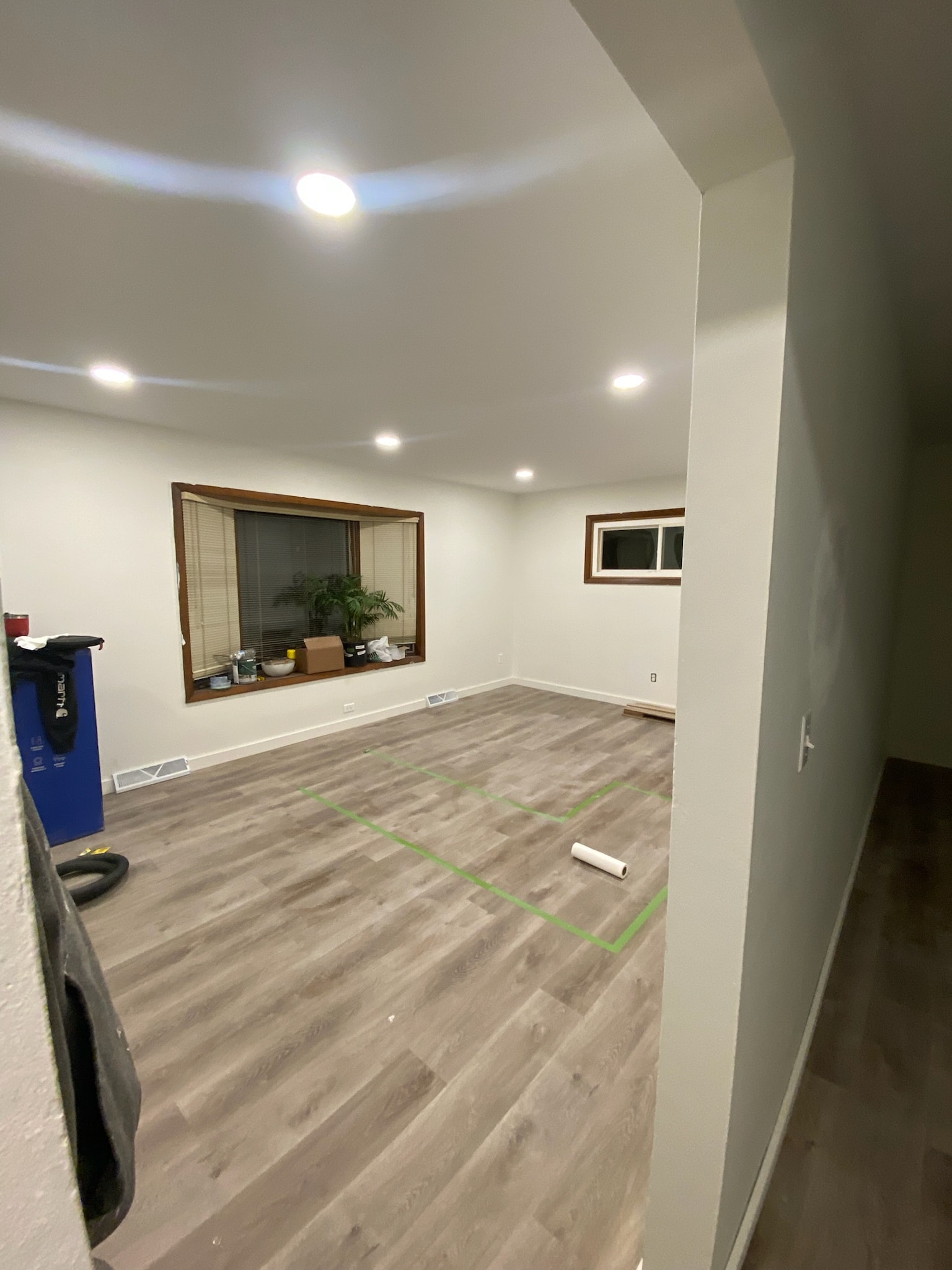 Finished ceiling with recessed lights on, patches painted smooth