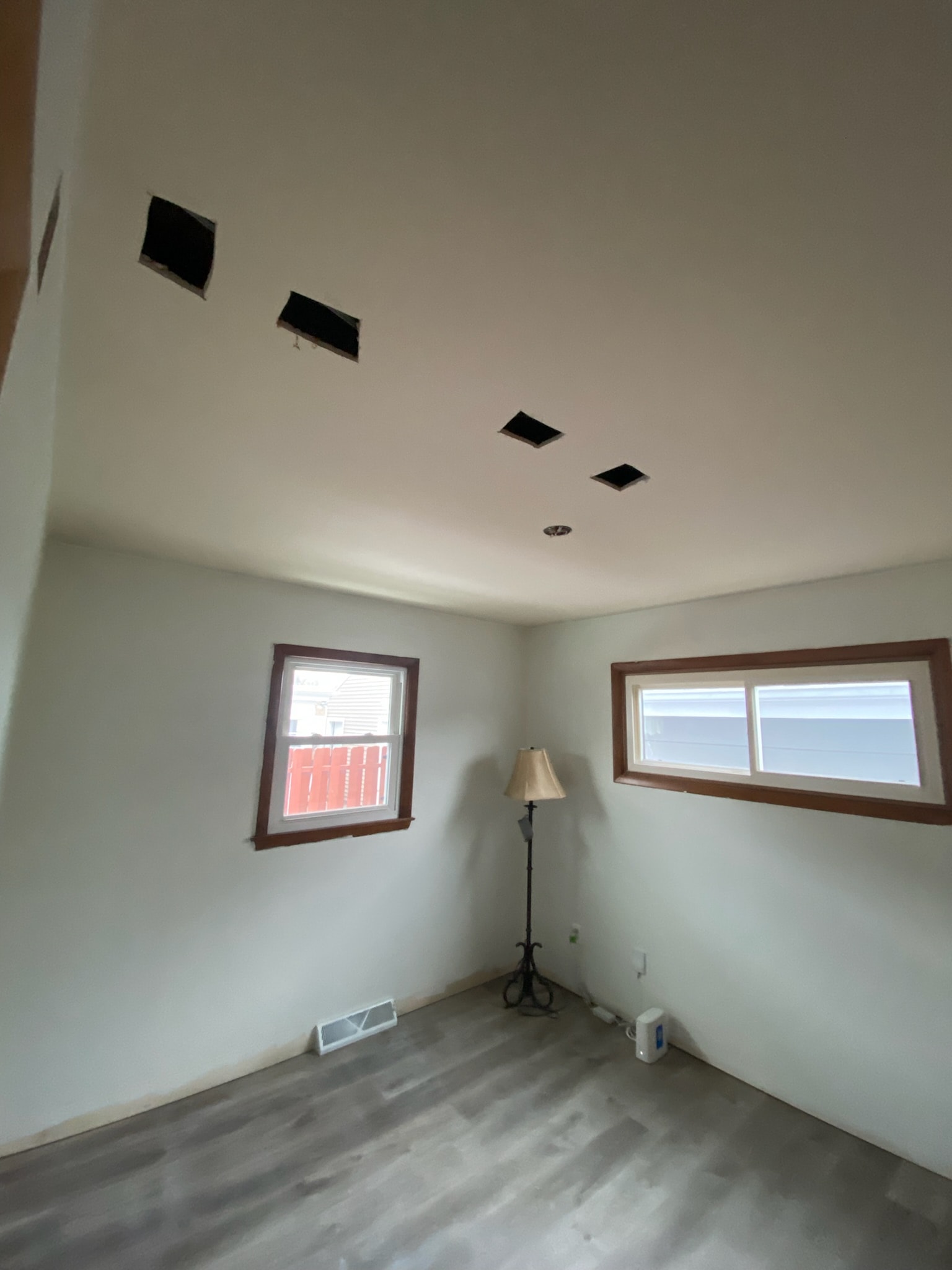 Ceiling with open cutouts after electrician installed recessed lighting
